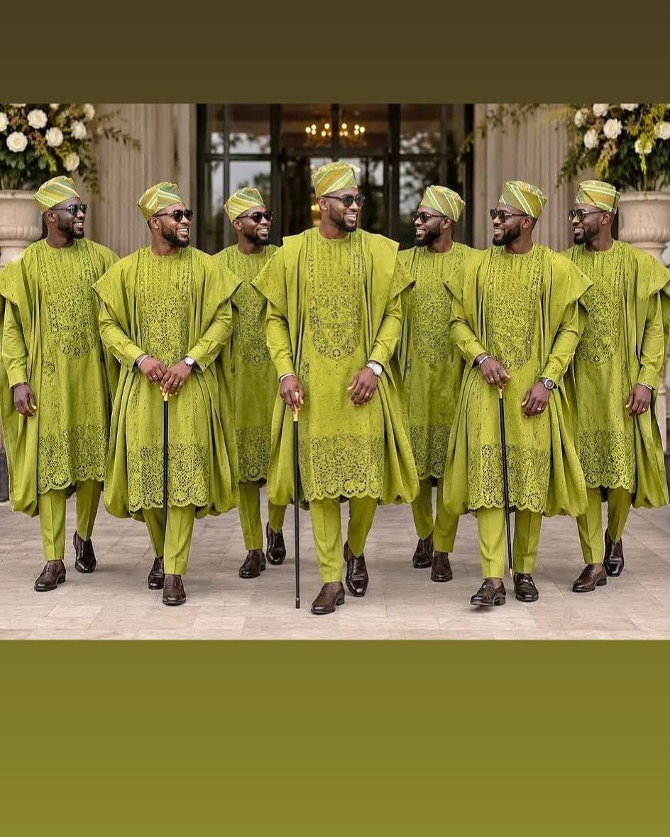 Seven men wearing coordinated green agbada outfits and matching caps for an aso-ebi celebration