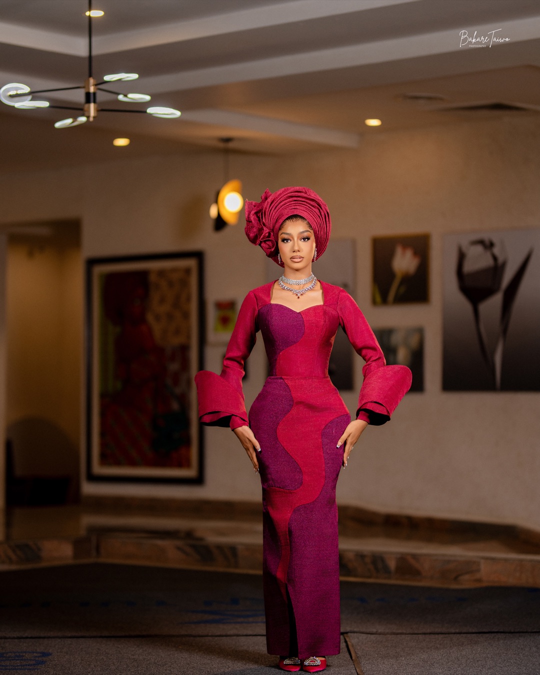 Full-length magenta and plum occasion dress with a matching gele